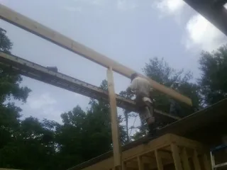 Carpenter setting a ridge beam over a new addition frame — Ice Dam Removal by Roofing Brothers in Spring House