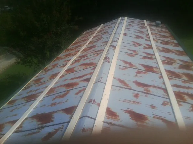 Rusted metal roof panels with new wood purlins before replacement — Storm Damage Roof Repair in Spring House by Roofing Brothers