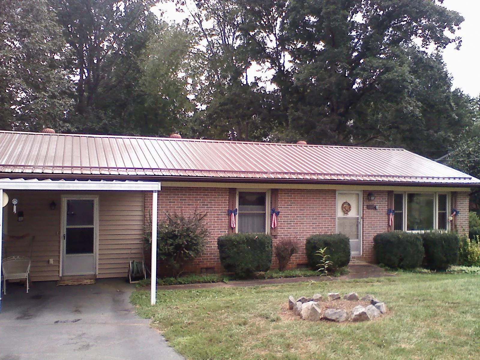 Bronze metal roof and carport on a brick ranch home — Roof Repair work by our crew in Spring House